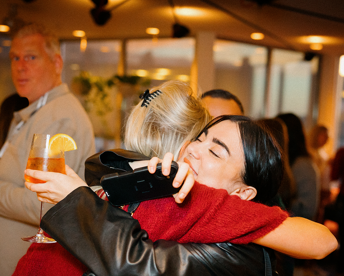 Professionals networking at an evening event with drinks and conversation